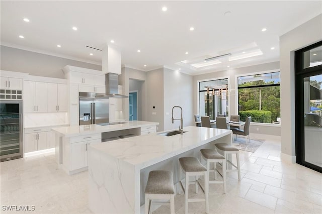 kitchen with a spacious island, built in refrigerator, ornamental molding, black electric cooktop, and a sink