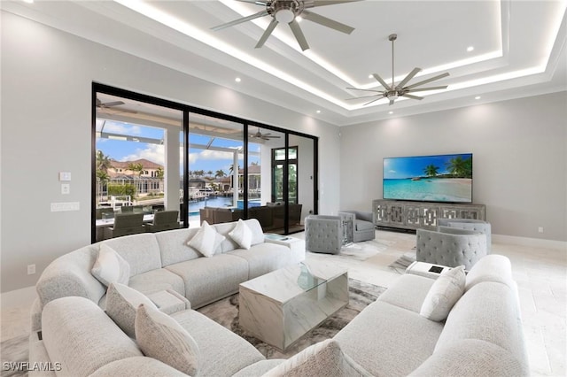 living area with recessed lighting, baseboards, a raised ceiling, and a ceiling fan