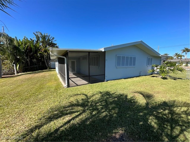 rear view of property featuring a lawn