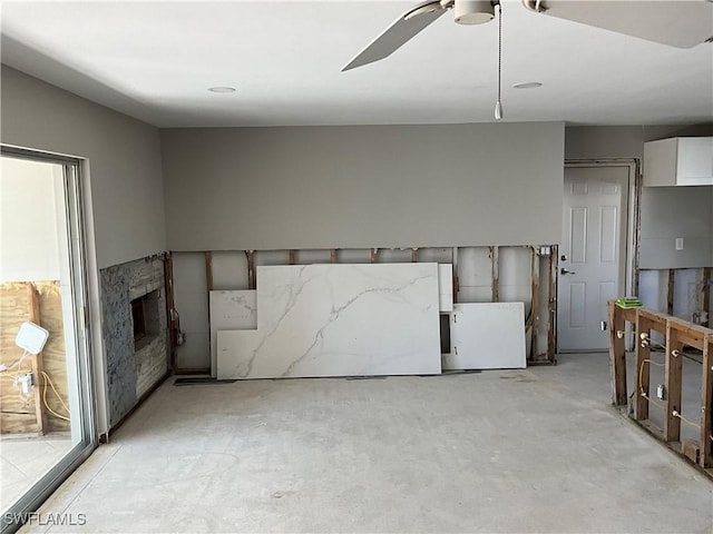 interior space with a fireplace and ceiling fan