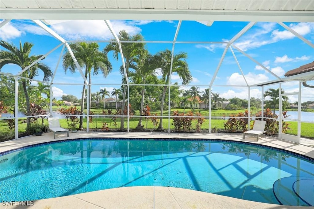 view of swimming pool featuring a patio, a lanai, and a water view