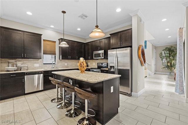 kitchen with hanging light fixtures, stainless steel appliances, a center island, a breakfast bar, and dark brown cabinetry