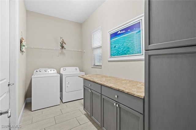 laundry room featuring washing machine and dryer and cabinets