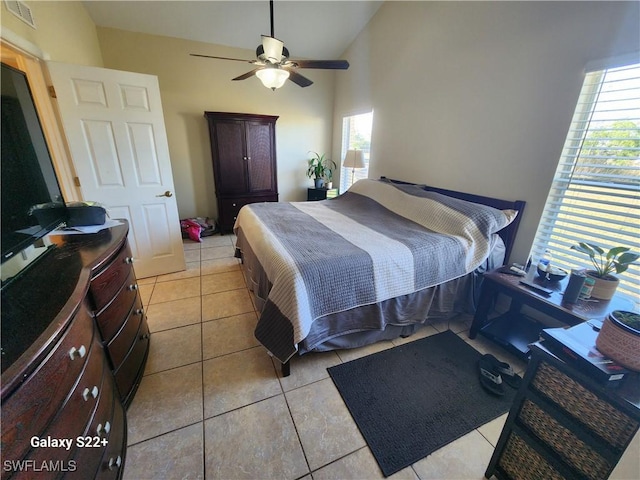 tiled bedroom with ceiling fan and lofted ceiling