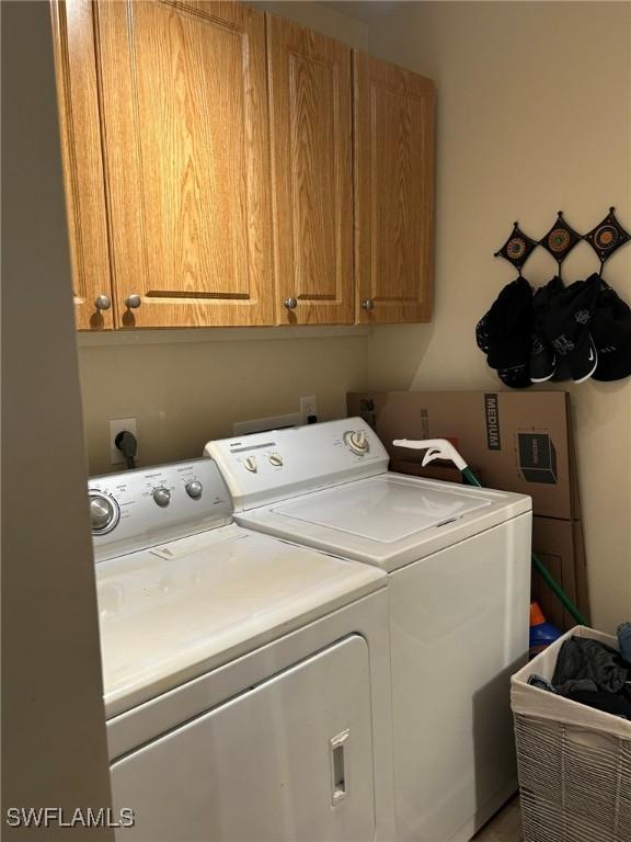 washroom with cabinets and washing machine and dryer