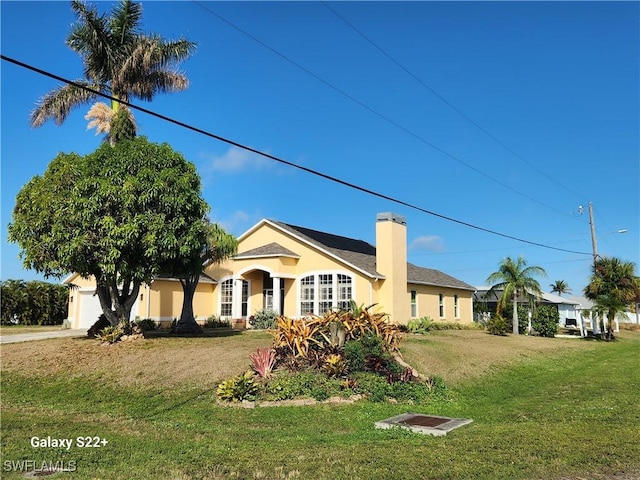 ranch-style home featuring a garage and a front lawn