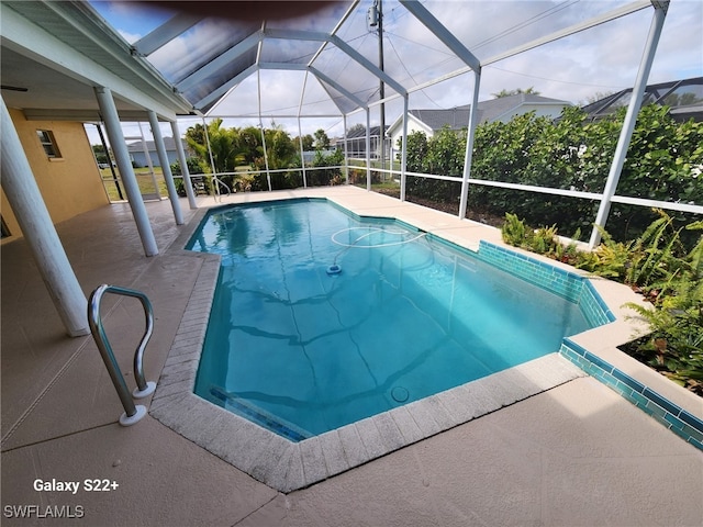 view of pool with glass enclosure