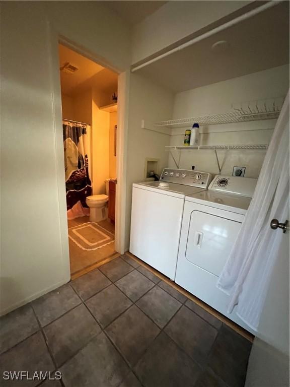 clothes washing area featuring washer and dryer and tile patterned flooring