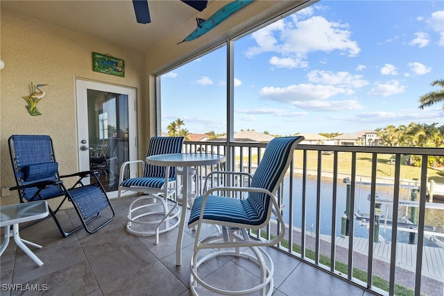 balcony with ceiling fan and a water view