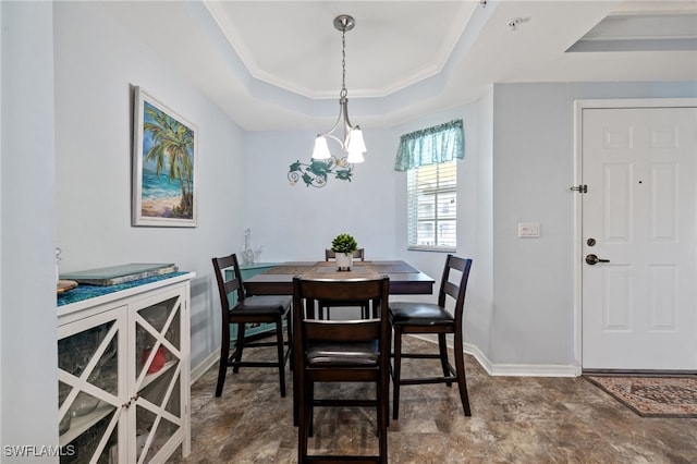 dining space with a tray ceiling and a notable chandelier