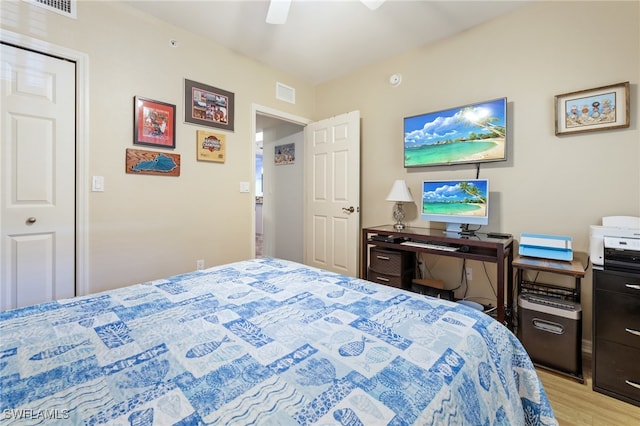 bedroom featuring a closet, light hardwood / wood-style floors, and ceiling fan