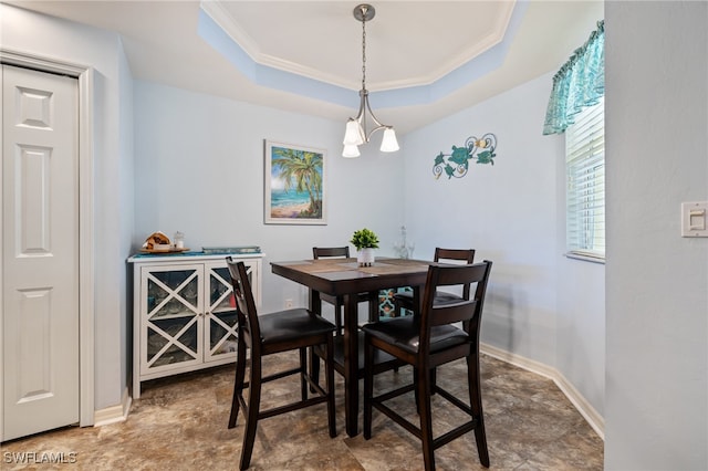 dining room featuring a tray ceiling, crown molding, and a chandelier