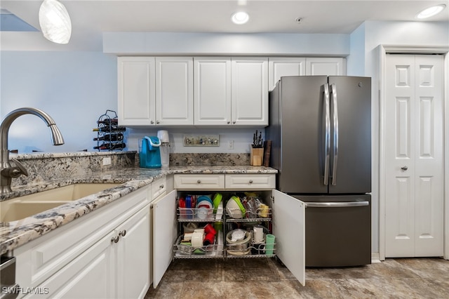 kitchen featuring white cabinets, stainless steel fridge, and sink