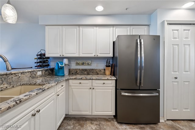 kitchen with stainless steel refrigerator, sink, and white cabinets