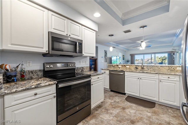 kitchen with stainless steel appliances, a tray ceiling, ceiling fan, sink, and white cabinets