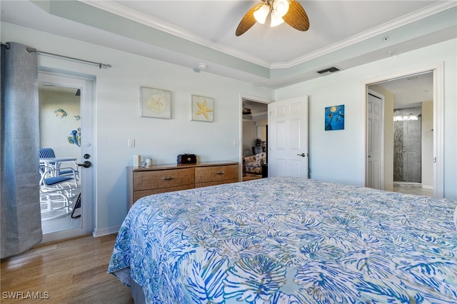 bedroom featuring a tray ceiling, connected bathroom, ceiling fan, and ornamental molding