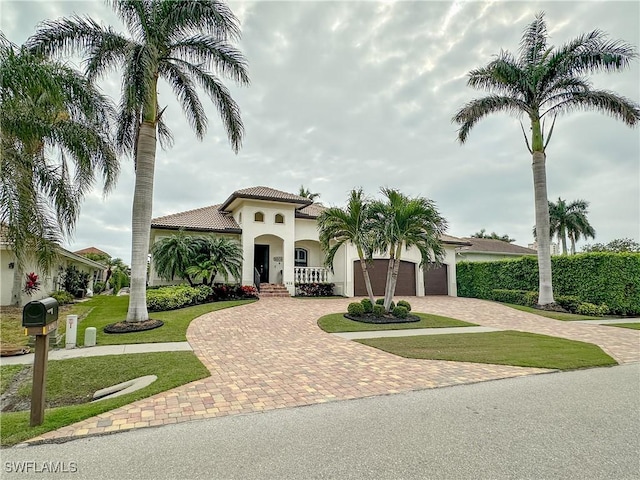 mediterranean / spanish-style home featuring a garage and a front yard