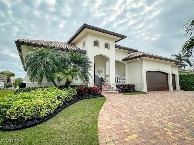 mediterranean / spanish-style house featuring a garage and a front yard