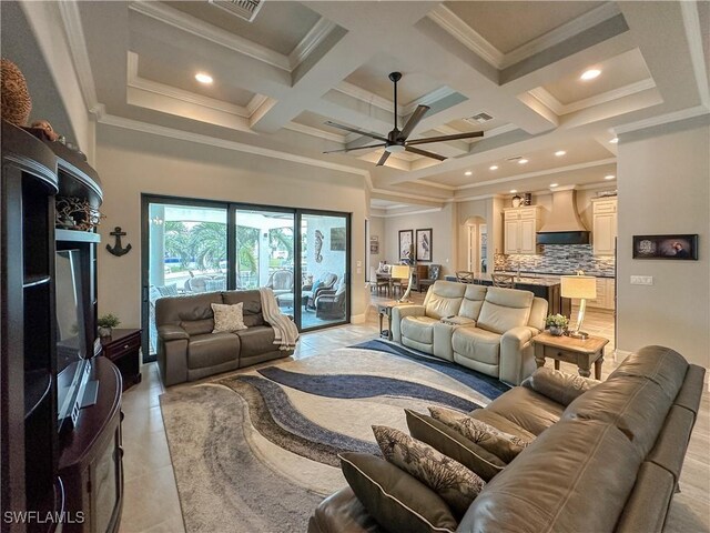 living room with ceiling fan, beam ceiling, a high ceiling, coffered ceiling, and ornamental molding