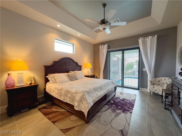 bedroom with ceiling fan, a raised ceiling, access to outside, and multiple windows