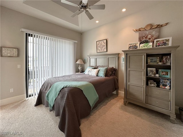 bedroom featuring ceiling fan, access to exterior, light colored carpet, and a raised ceiling