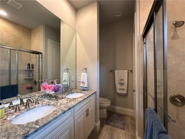 bathroom featuring an enclosed shower, vanity, tile patterned floors, and toilet