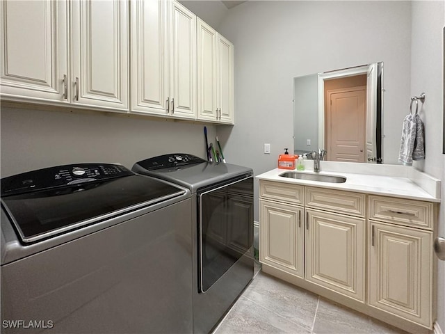 laundry area with sink, washing machine and dryer, and cabinets