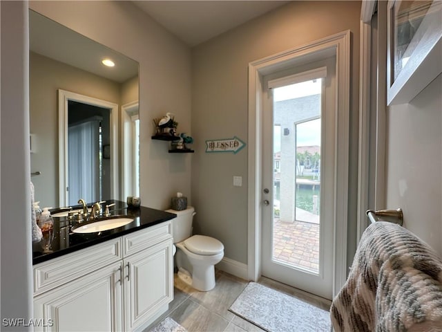 bathroom featuring tile patterned floors, vanity, and toilet