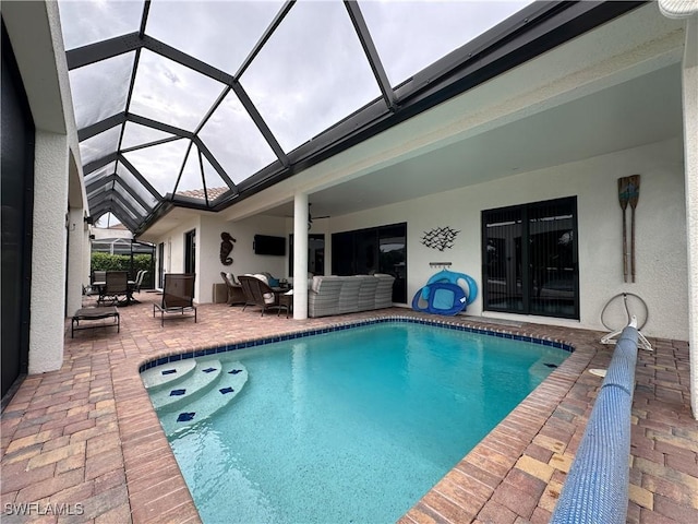 view of pool featuring an outdoor living space, a patio, ceiling fan, and glass enclosure