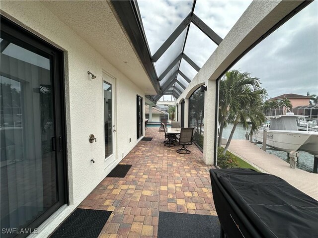 view of patio / terrace featuring a lanai and a dock