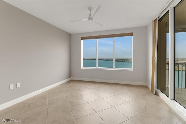 empty room with ceiling fan and a water view