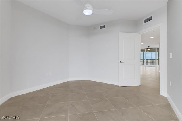 tiled empty room featuring ceiling fan