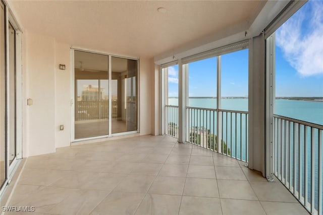 unfurnished sunroom featuring a water view