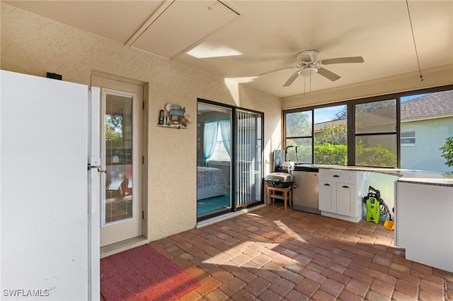 unfurnished sunroom with ceiling fan