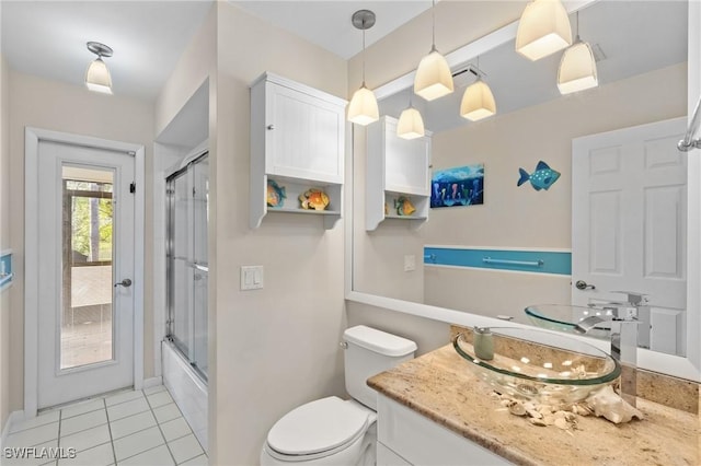 full bathroom featuring tile patterned flooring, vanity, toilet, and bath / shower combo with glass door