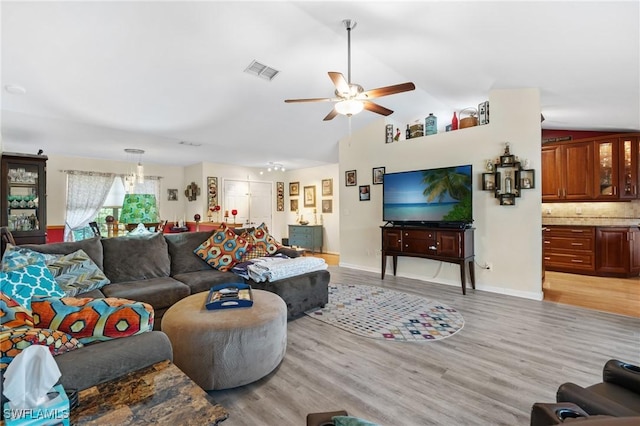 living room with ceiling fan, light hardwood / wood-style floors, and lofted ceiling