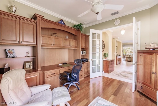 office area with built in desk, french doors, ceiling fan, ornamental molding, and light hardwood / wood-style floors