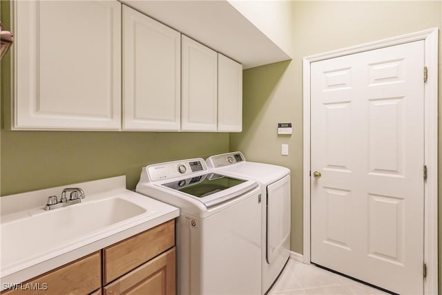 washroom with sink, light tile patterned floors, cabinets, and independent washer and dryer