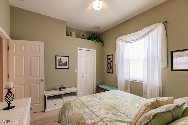 carpeted bedroom with ceiling fan and a closet