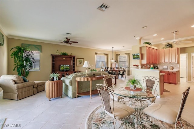 dining area with ceiling fan, crown molding, and light tile patterned flooring