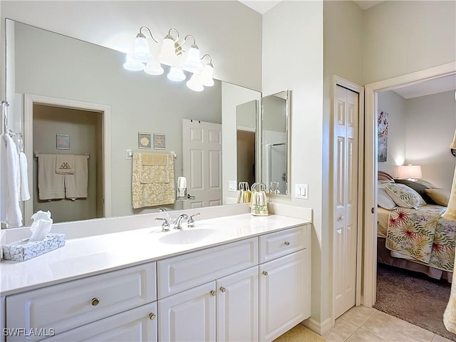 ensuite bathroom featuring tile patterned flooring, a closet, connected bathroom, and vanity