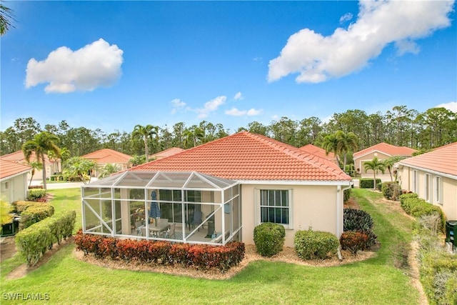 back of property featuring glass enclosure, a lawn, a tiled roof, and stucco siding