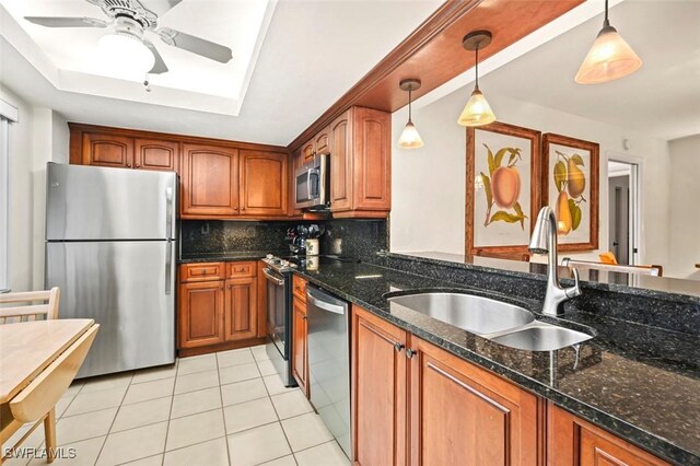 kitchen featuring stainless steel appliances, sink, decorative light fixtures, light tile patterned floors, and backsplash