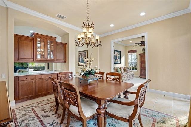 tiled dining space with ceiling fan with notable chandelier and ornamental molding