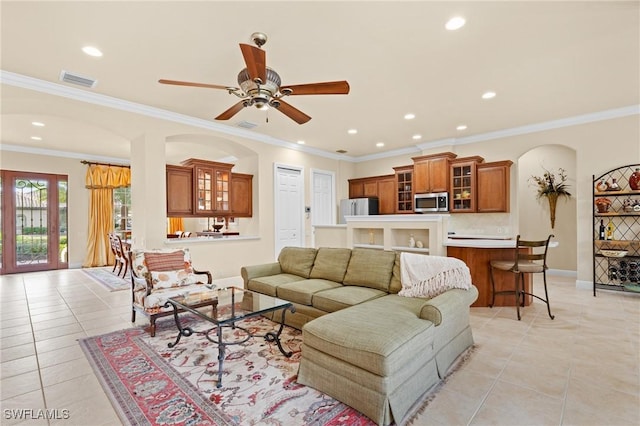 living room featuring ceiling fan, light tile patterned floors, and crown molding