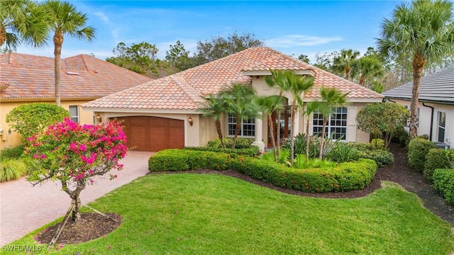 mediterranean / spanish house with a front lawn and a garage