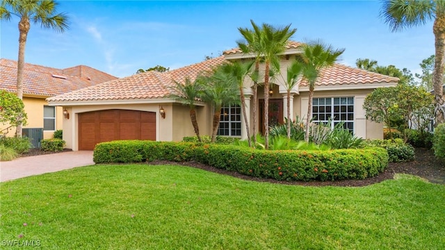 mediterranean / spanish house featuring a front yard and a garage