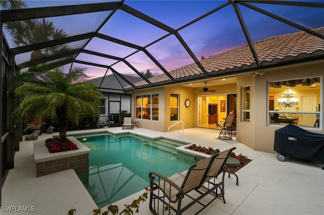 view of pool with ceiling fan, a patio area, and glass enclosure