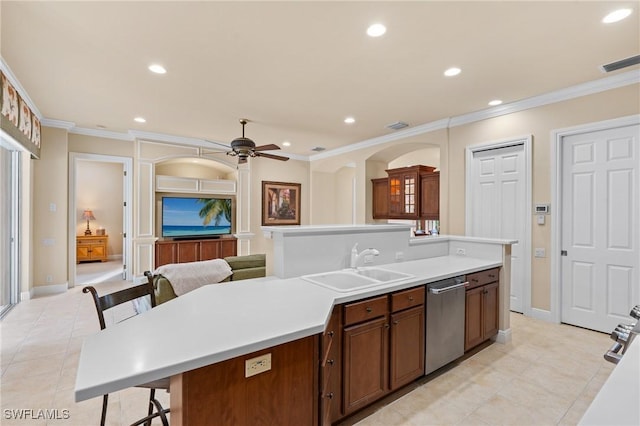 kitchen featuring ceiling fan, dishwasher, a center island with sink, sink, and ornamental molding