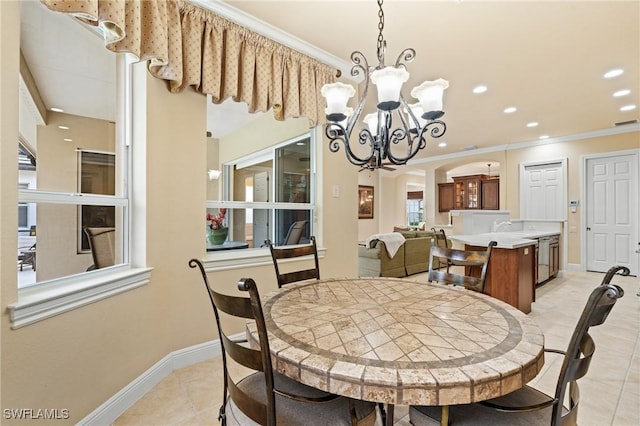 dining area featuring light tile patterned floors, a chandelier, and crown molding